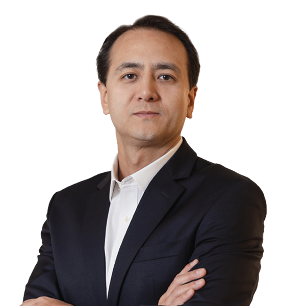 Sócio Guilherme Woo Terra está vestindo um paletó preto e camisa bege claro. Ele tem cabelo liso, curto e preto.