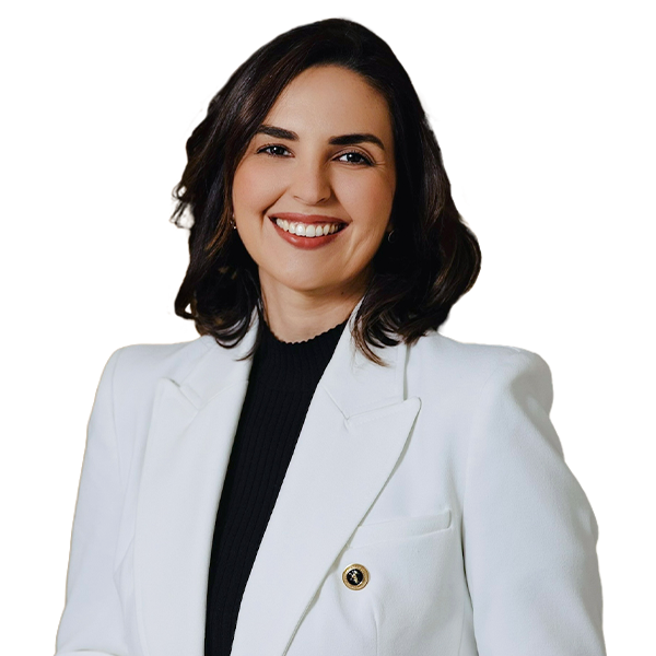 Janaína é branca, tem olhos castanhos, e cabelos castanhos na altura do pescoço. Usa uma blusa preta sobreposta por um paletó branco.