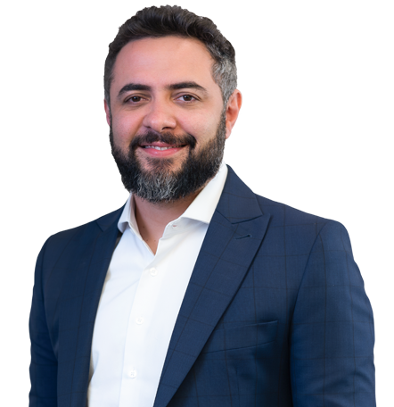 Raphael Saraiva, sócio do escritório Mattos Filho. Homem, com barba e cabelo curto preto, usando um blazer azul e uma camisa social branca.