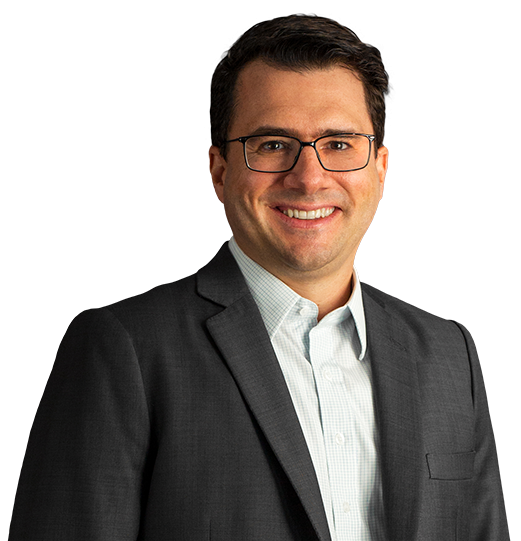 Sócio Rodrigo Figueiredo Nascimento está vestindo um terno preto e camisa tom gelo. Tem cabelo curto, castanho escuro e liso, usa óculos e está com um largo sorriso.