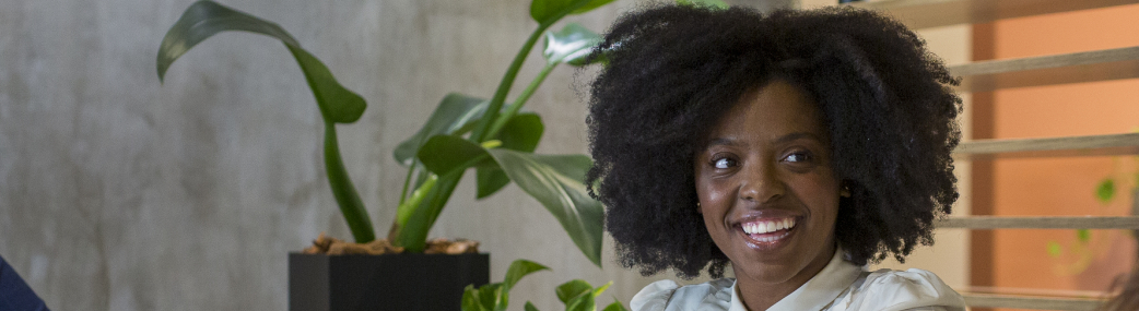 colaboradora negra, com belos cabelos black power, no escritório do mattos filho