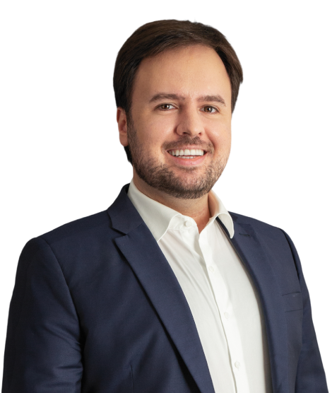 O sócio Anderson está com um largo sorriso na foto. Ele veste um paletó azul marinho e camisa social branca. Seus cabelos e barba são castanho claro.