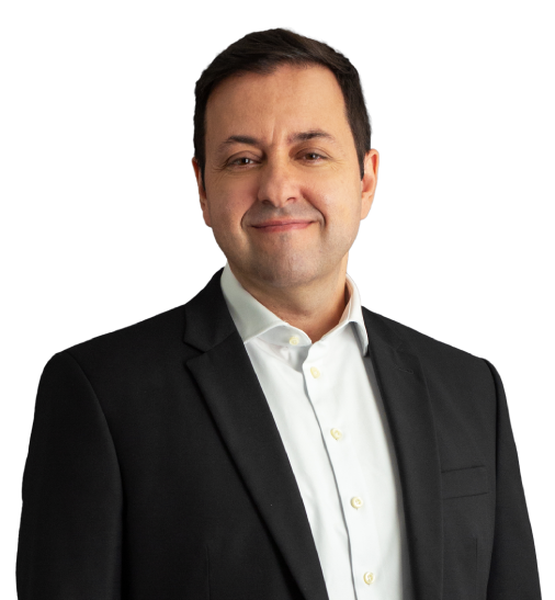 Domingos possui cabelos curtos e bem escuros. Na foto, está com uma expressão leve e alegre, usando um blazer preto e blusa social branca por baixo.