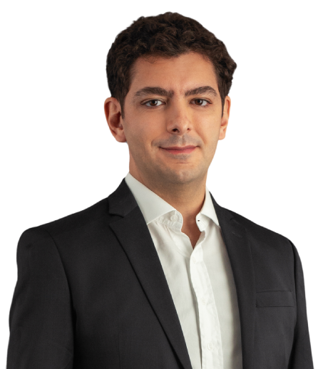 O sócio João Vicente veste um paletó preto com camisa social branca. Ele tem cabelos castanho. Na foto, está com um leve sorriso.