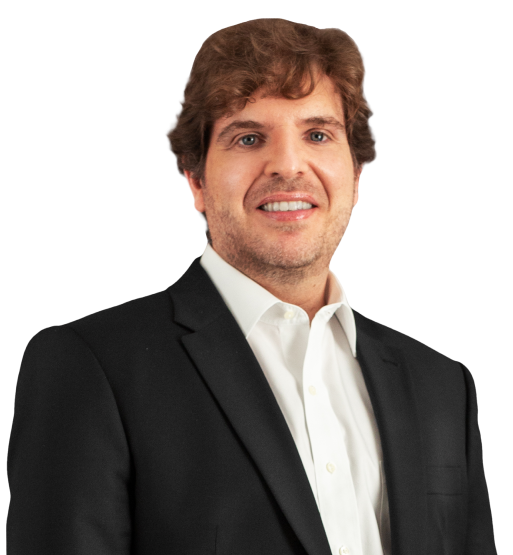 O sócio marcelo ricupero tem cabelos ruivos e levemente ondulados. A barba está por fazer. Na foto, está com um leve sorriso, e usa paletó preto com blusa social branca por baixo.