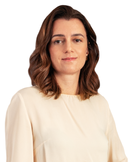 A sócia nicole moreira tem cabelos na altura dos ombros, castanhos, com luzes nas pontas. Está usando uma blusa em tom rosa claro. Na foto, está com uma expressão facial leve.