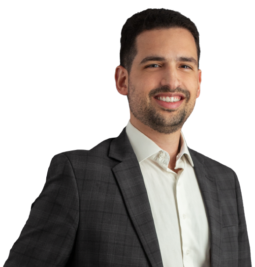 Sócio Rafael de Filippis está vestindo um terno cinza xadrez escuro e camisa creme. Ele tem cabelo curto e cavanhaque escuro e está com um largo sorriso.