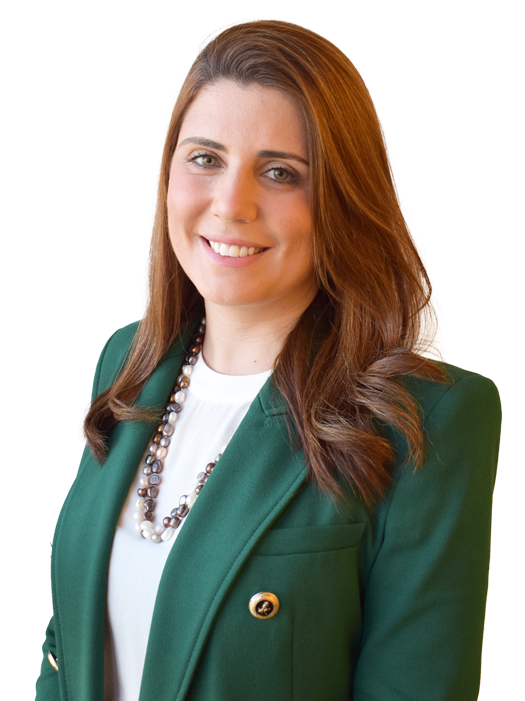 Mulher branca de cabelos castanho acobreado usando blazer verde e camiseta branca