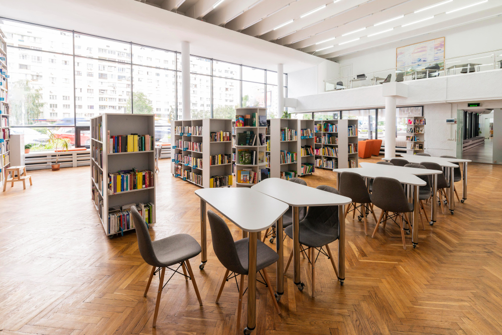 Laboratório de estudo, com mesas, cadeiras e prateleiras de livros