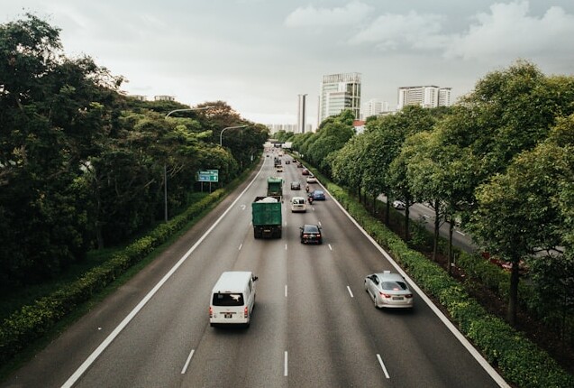 imagem de rodovia com carros passando e arvores ao redor