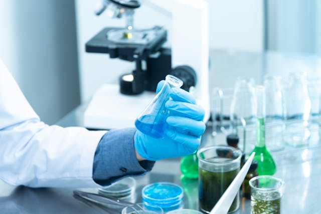 Pessoa segurando frasco de laboratório