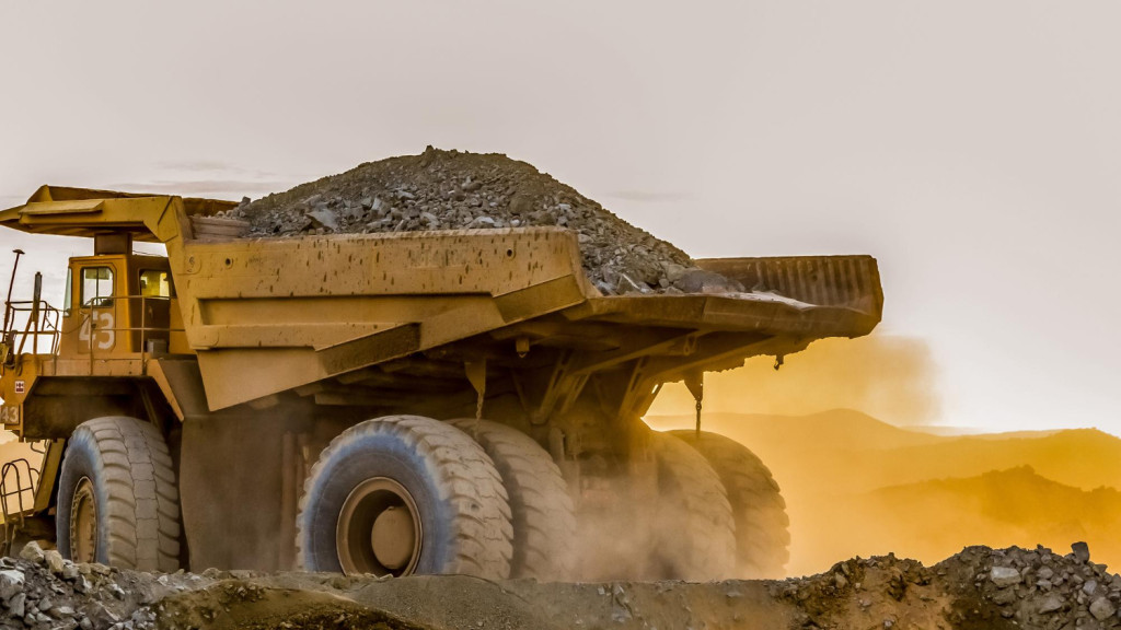 Grande caminhão carregando areia em um local de mineração de platina