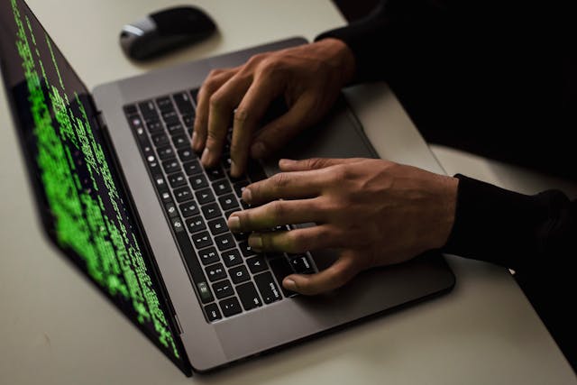 Imagem representando cybersegurança. Homem digitando códigos em computador.