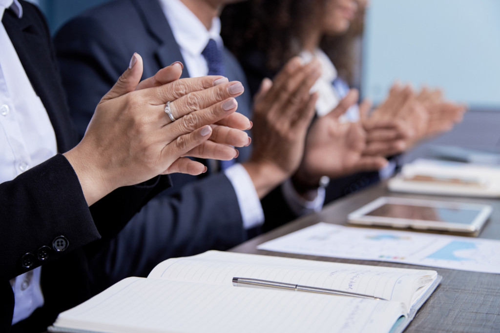 Colegas de conselho a aplaudirem a reunião.