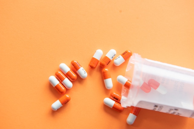 Pílulas de medicação laranja e branco.