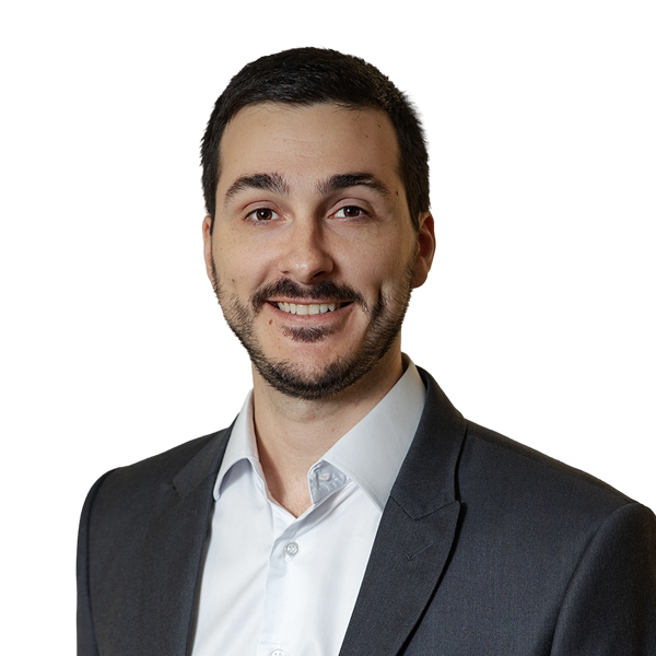 Fábio Perez é branco, com cabelos pretos, olhos castanhos, e barba curta. Na foto, usa uma camisa branca e um paletó cinza.