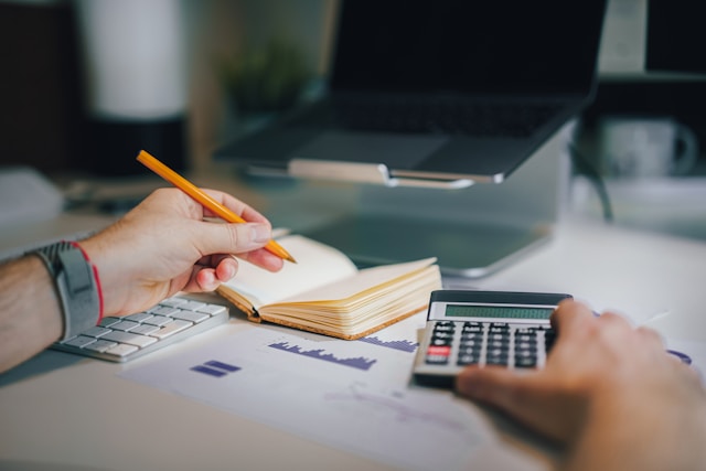 Homem fazendo contas e anotações para se organizar financeiramente